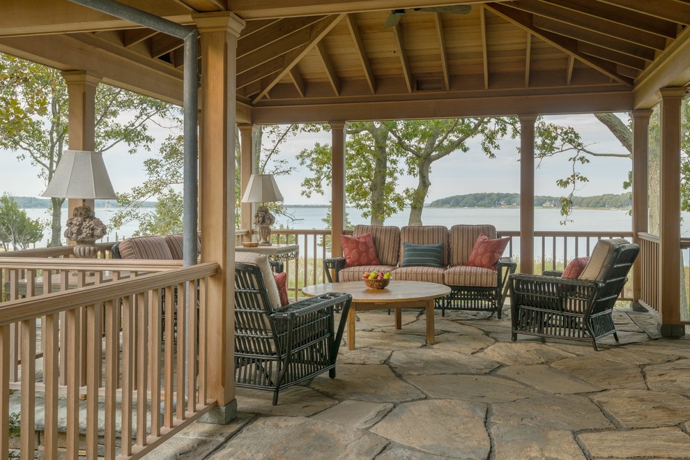 Inspiration for a large classic back patio in New York with natural stone paving and a gazebo.
