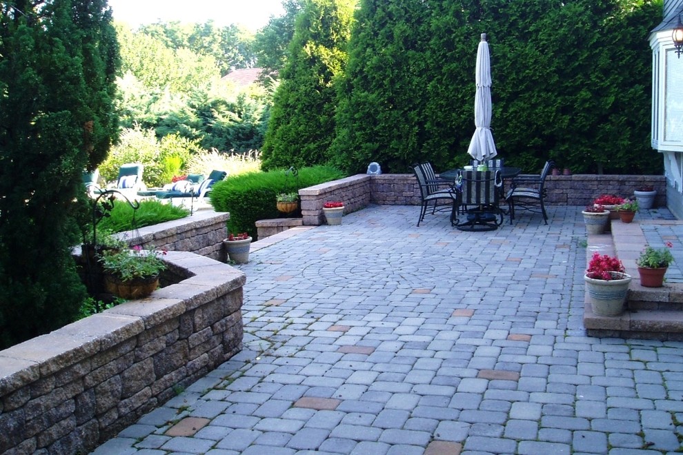 Example of a mid-sized transitional backyard brick patio design in New York with no cover