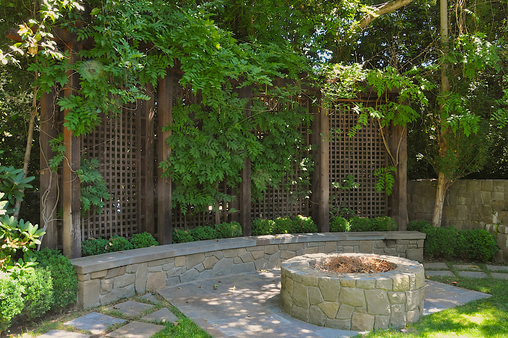 На фото: двор в классическом стиле с местом для костра без защиты от солнца с