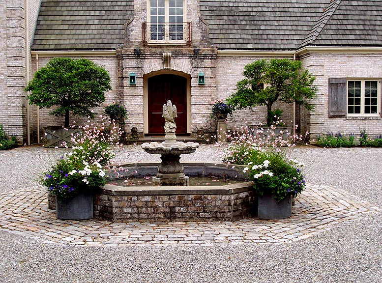 This is an example of a classic patio in New York with a water feature and gravel.