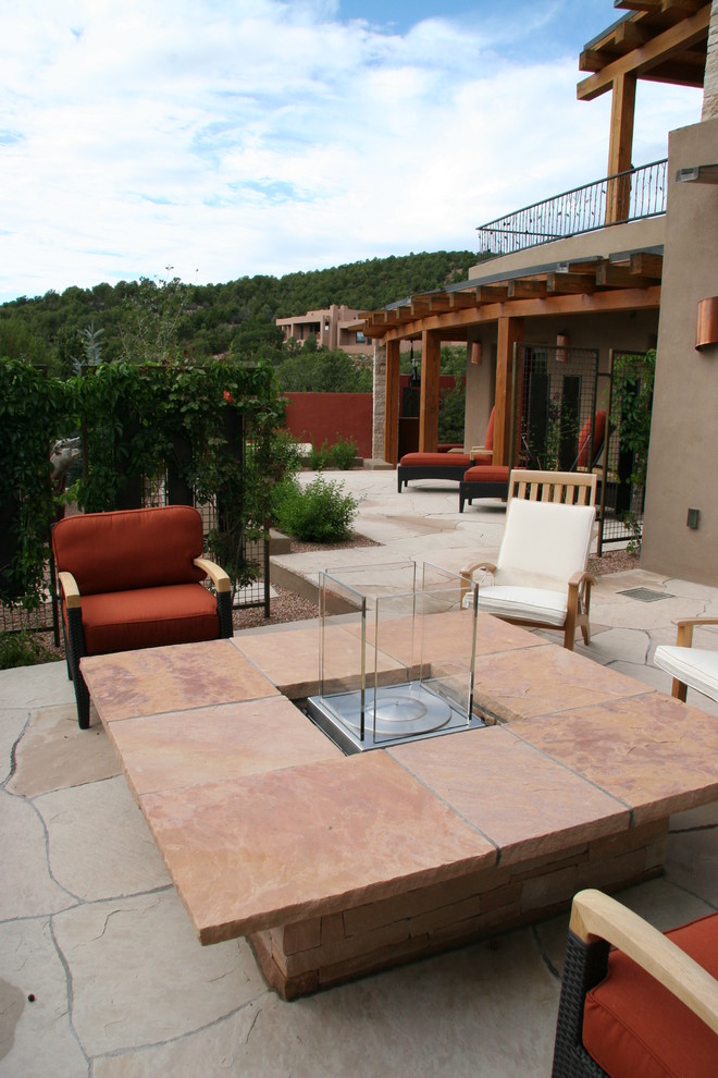 Moderner Patio hinter dem Haus mit Feuerstelle und Natursteinplatten in Albuquerque