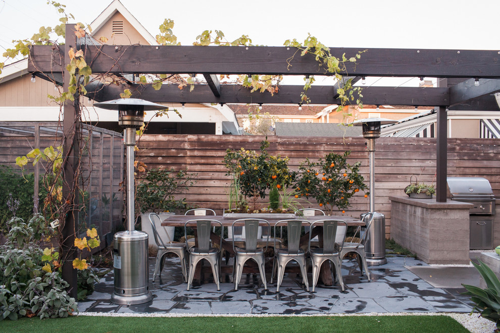 Foto di un grande patio o portico design dietro casa con un giardino in vaso, pavimentazioni in pietra naturale e una pergola