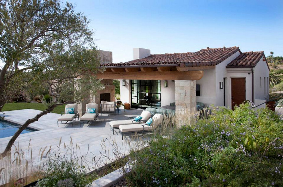 Foto di un grande patio o portico mediterraneo dietro casa con pavimentazioni in pietra naturale e nessuna copertura