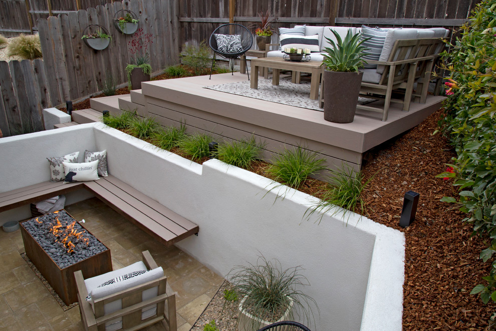 Idee per un piccolo patio o portico minimalista dietro casa con un focolare e pavimentazioni in cemento