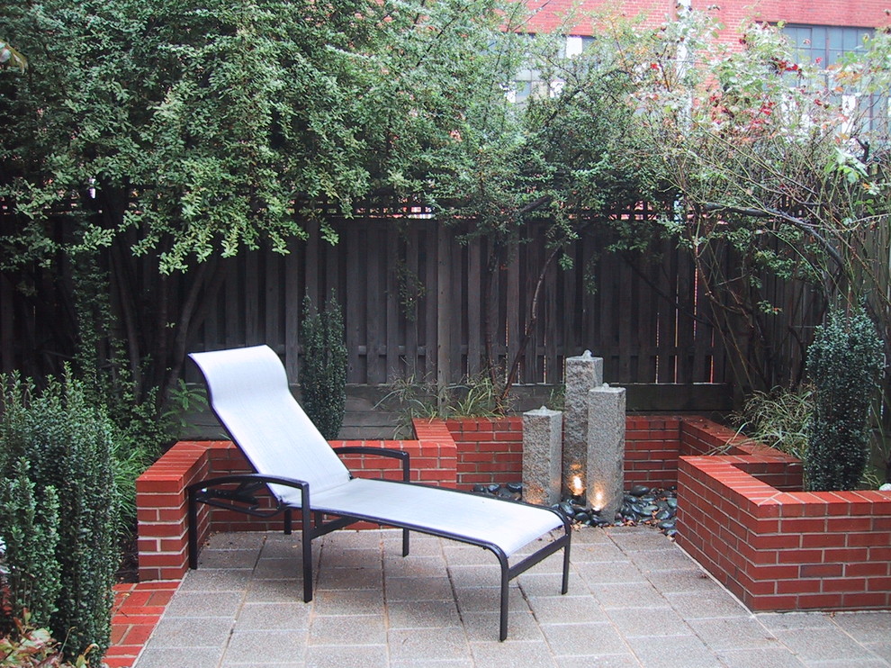 Esempio di un patio o portico design di medie dimensioni e dietro casa con piastrelle e nessuna copertura
