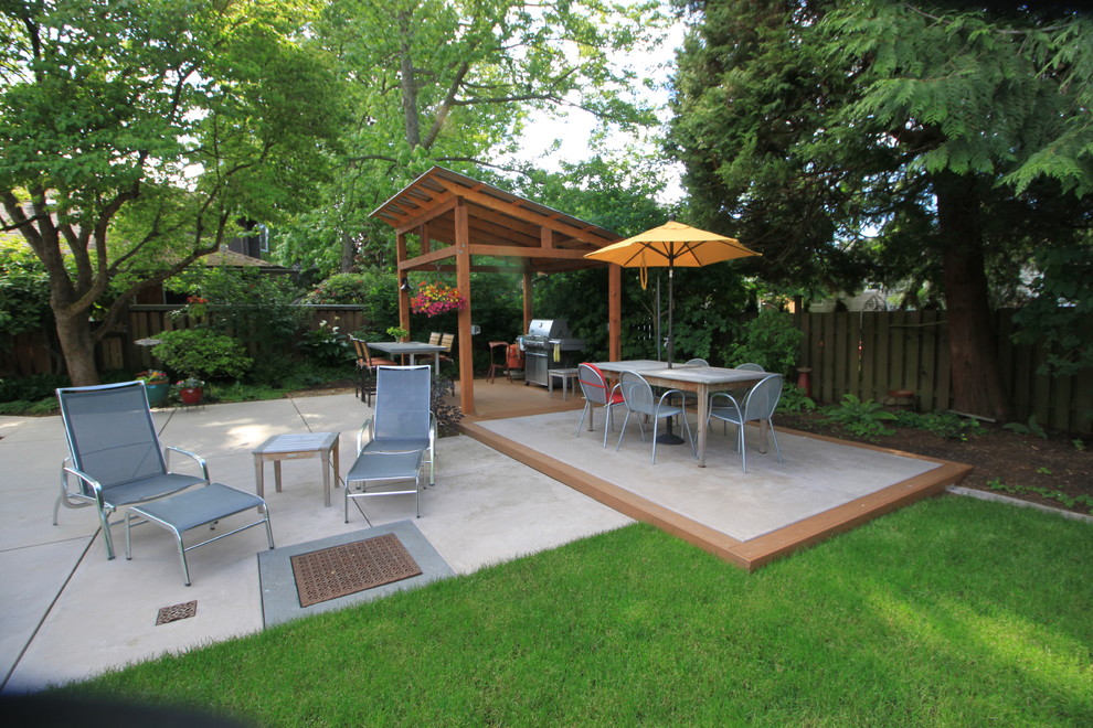 Exemple d'une grande terrasse arrière tendance avec une cuisine d'été, une dalle de béton et un gazebo ou pavillon.