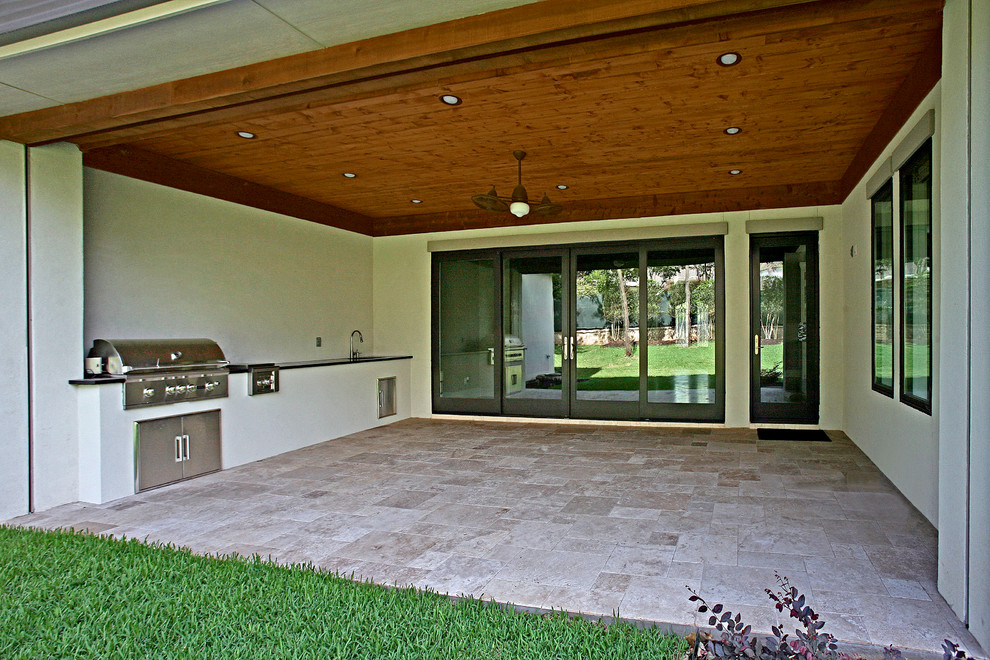 Example of a large trendy backyard stone patio kitchen design in Dallas with a roof extension