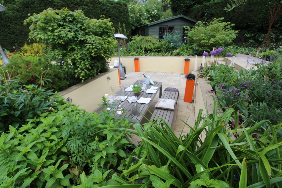 Großer, Unbedeckter Moderner Patio hinter dem Haus mit Natursteinplatten in Essex