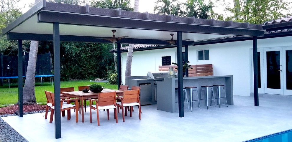 Пример оригинального дизайна: двор среднего размера на заднем дворе в современном стиле с летней кухней, мощением тротуарной плиткой и навесом