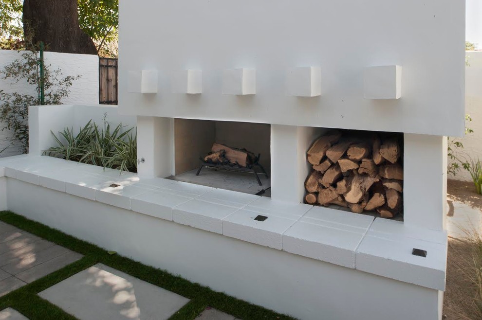 Idées déco pour une terrasse arrière contemporaine de taille moyenne avec un foyer extérieur, des pavés en béton et aucune couverture.