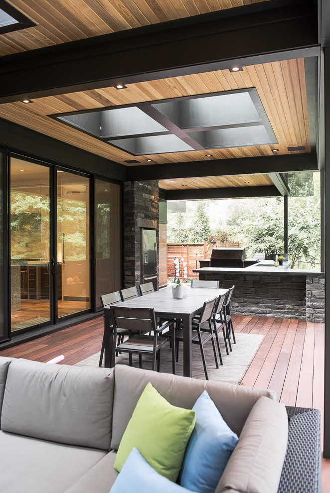 Design ideas for a contemporary back patio in Toronto with decking and a roof extension.