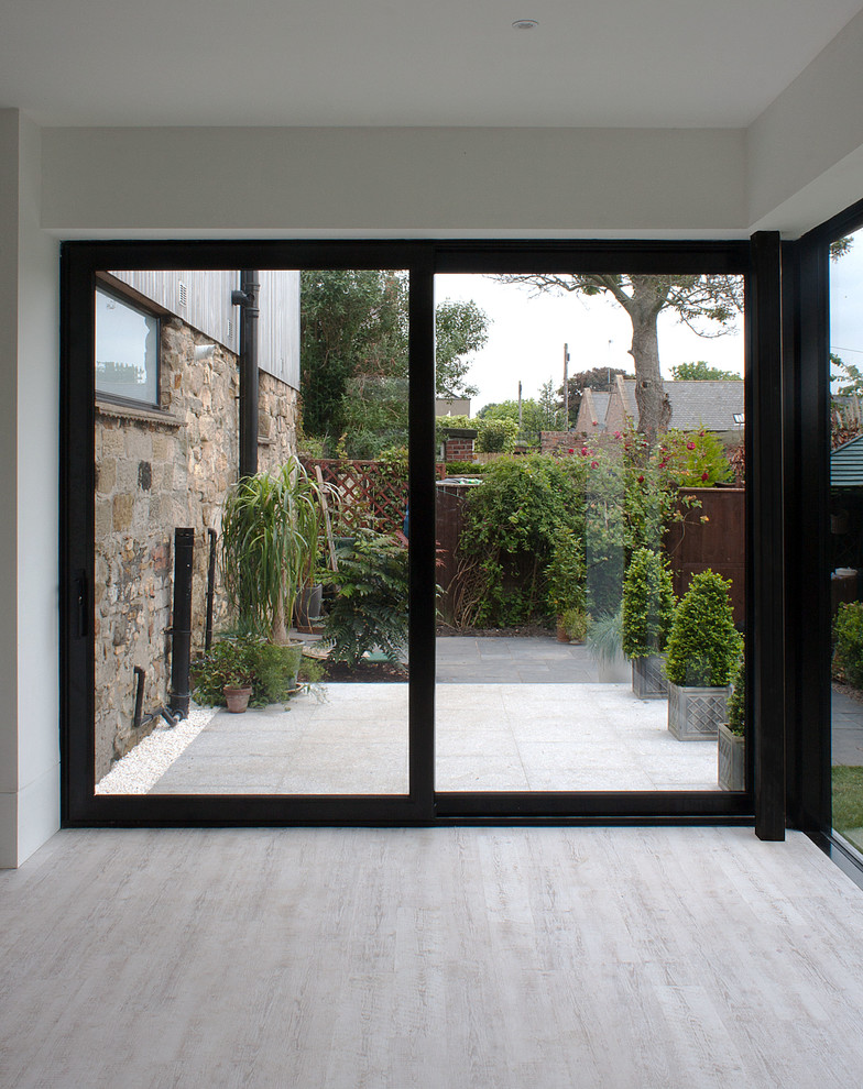 Esempio di un patio o portico minimal di medie dimensioni e dietro casa con pavimentazioni in pietra naturale e nessuna copertura