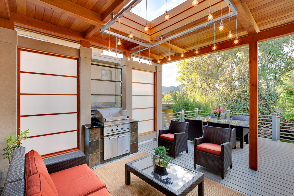 Inspiration pour une terrasse en bois design de taille moyenne avec une cour et une extension de toiture.