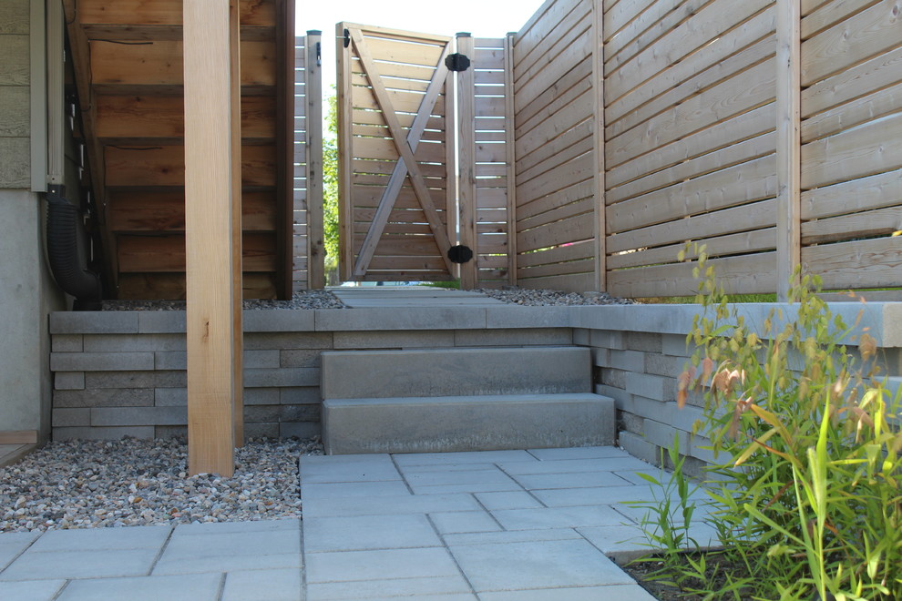 Design ideas for a large contemporary back patio in Ottawa with brick paving.