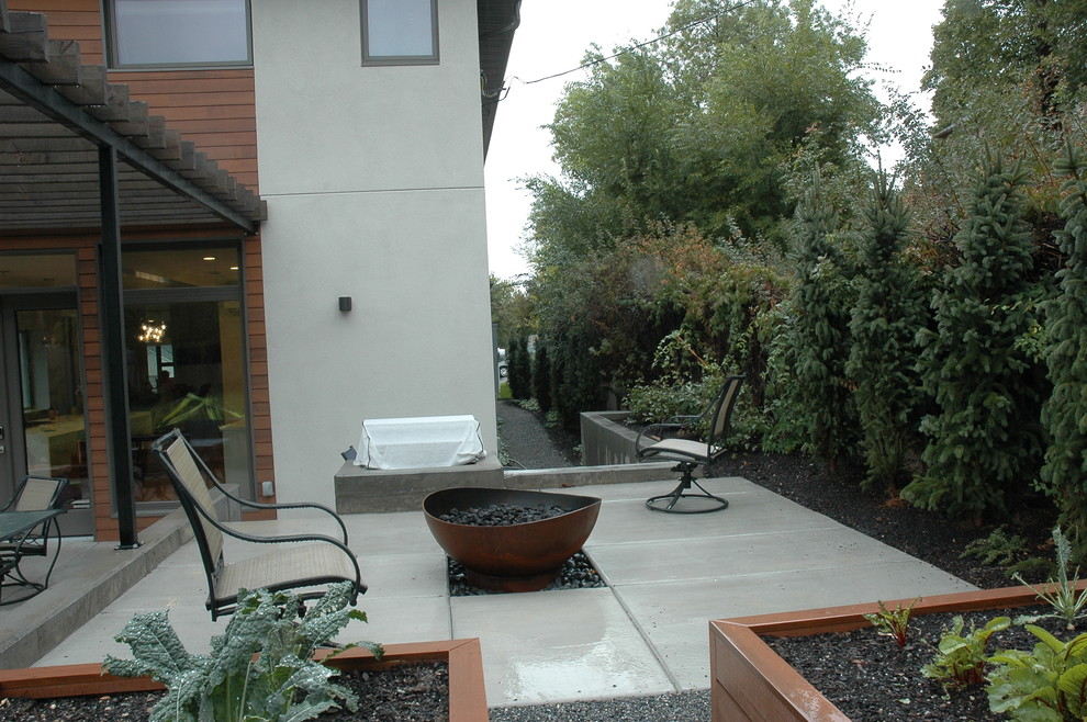 Medium sized modern back patio in Salt Lake City with a fire feature, concrete paving and a pergola.
