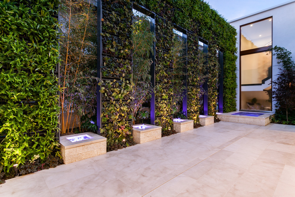 Idee per un ampio patio o portico design nel cortile laterale con pavimentazioni in pietra naturale