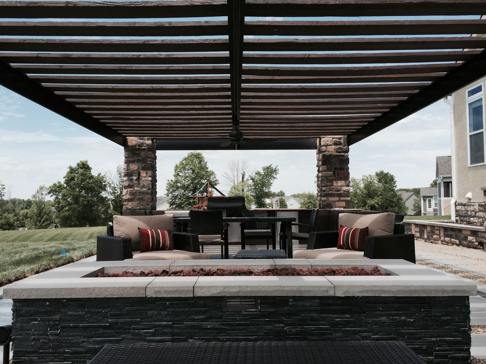 This is an example of a large contemporary back patio in Columbus with an outdoor kitchen, concrete paving and a pergola.
