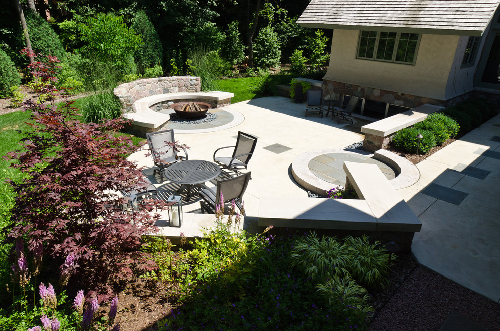 Example of a large arts and crafts backyard concrete patio design in Milwaukee with a fire pit