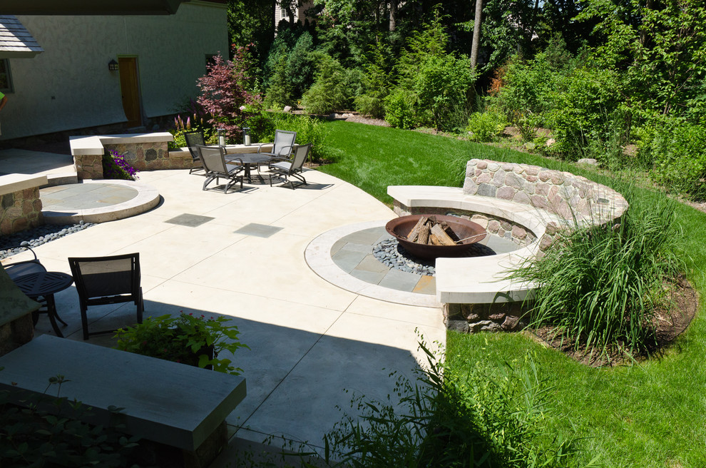 Design ideas for a large contemporary back patio in Milwaukee with a fire feature and concrete slabs.