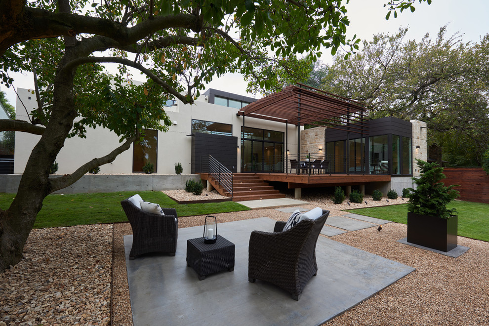Idee per un grande patio o portico contemporaneo dietro casa con una pergola e lastre di cemento