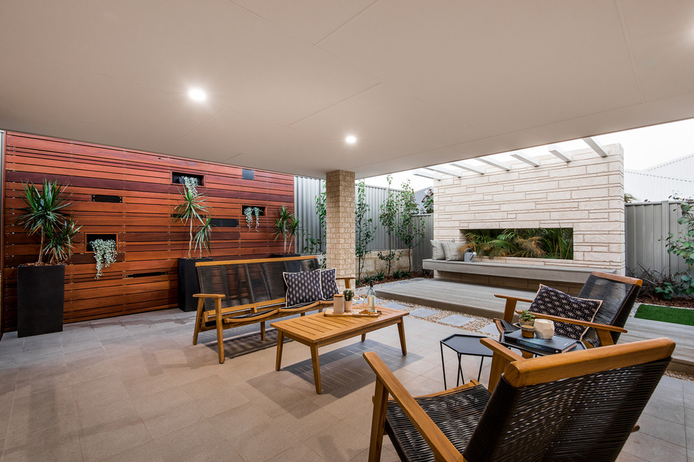 Стильный дизайн: двор среднего размера на заднем дворе в современном стиле с покрытием из плитки, навесом и забором - последний тренд