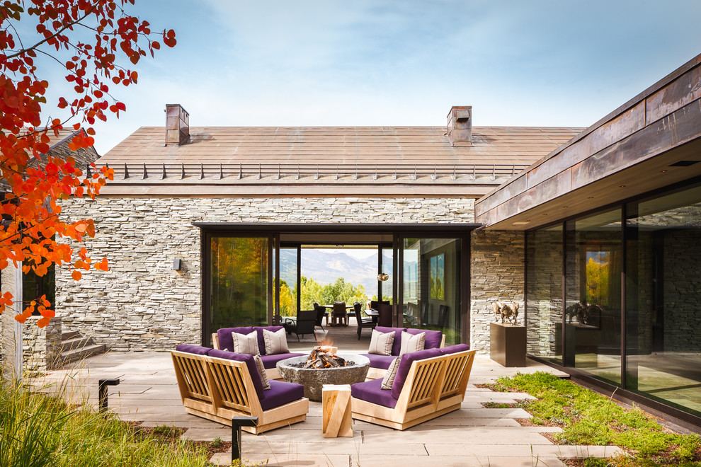 Inspiration pour une terrasse latérale rustique de taille moyenne avec un foyer extérieur, aucune couverture et des pavés en béton.