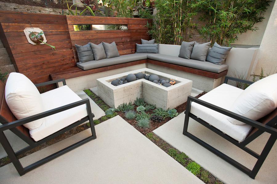 Foto di un piccolo patio o portico design in cortile con un focolare, pavimentazioni in cemento e nessuna copertura