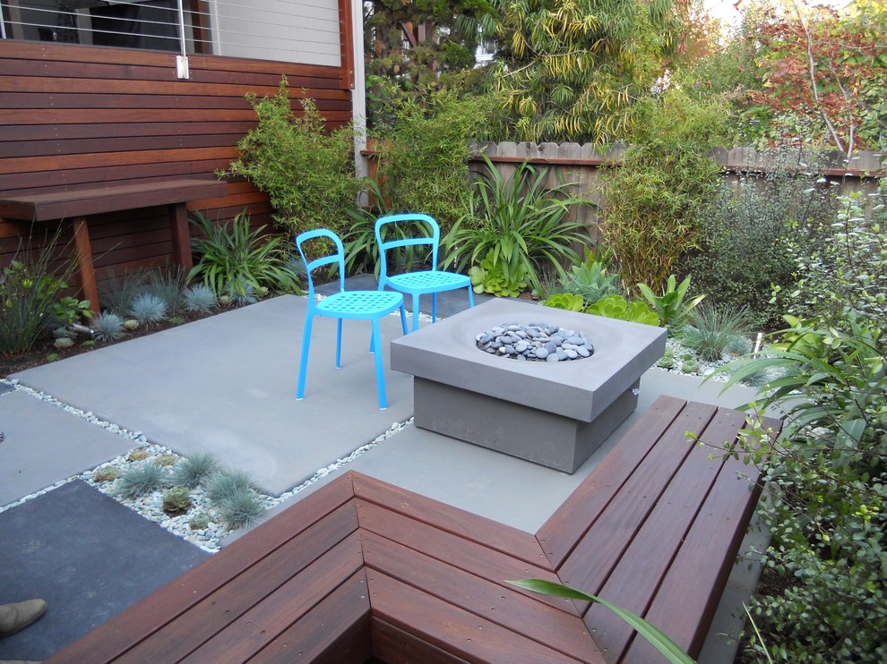 Idée de décoration pour une terrasse arrière design avec un foyer extérieur.