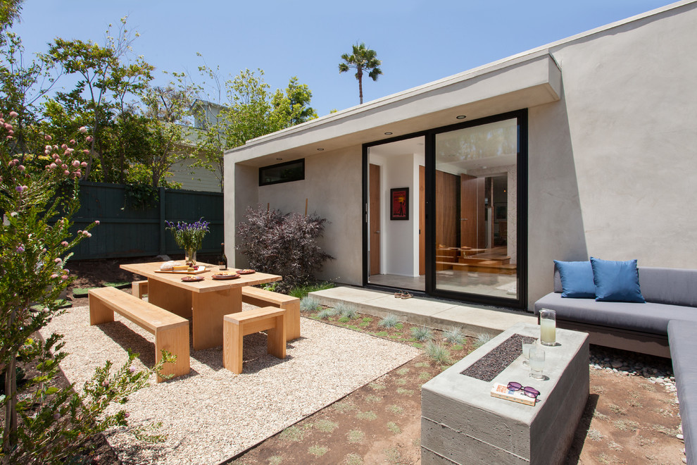 На фото: двор среднего размера на заднем дворе в современном стиле с покрытием из гравия без защиты от солнца с