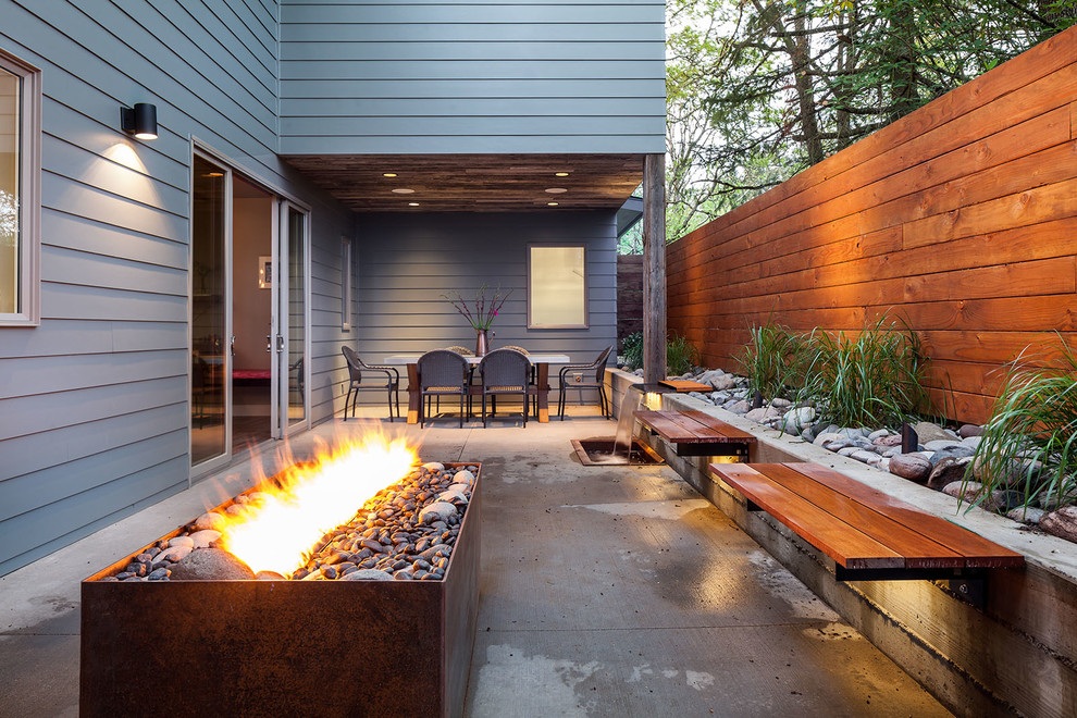 Mid-sized trendy backyard concrete patio photo in Other with a fire pit and no cover
