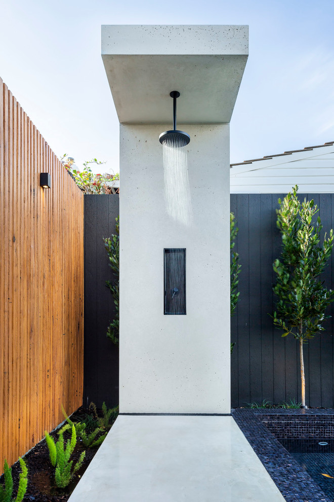 Idée de décoration pour une terrasse avec une douche extérieure arrière design avec une dalle de béton.
