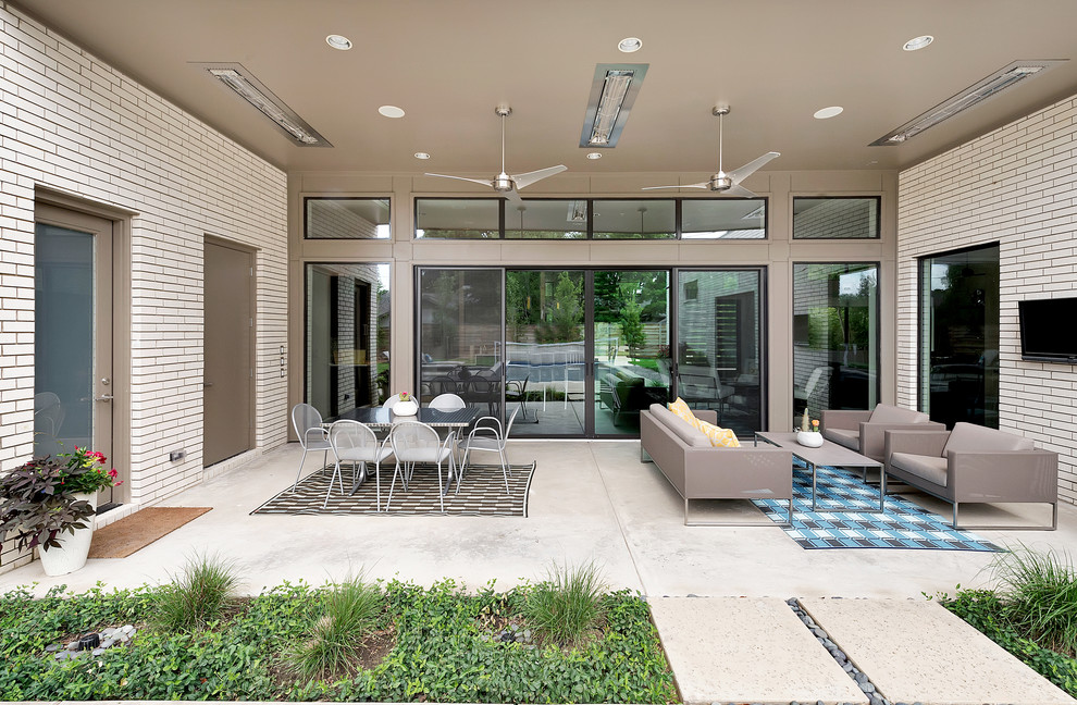 Idee per un patio o portico minimal dietro casa e di medie dimensioni con lastre di cemento e un tetto a sbalzo