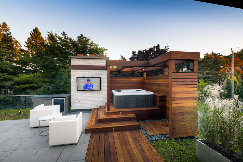 Idées déco pour une terrasse en bois arrière contemporaine de taille moyenne avec une pergola.