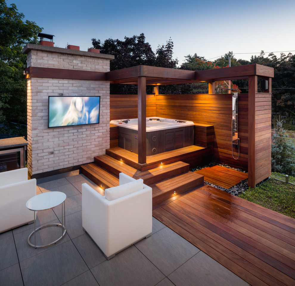 Example of a mid-sized trendy backyard outdoor patio shower design in Toronto with decking and a pergola