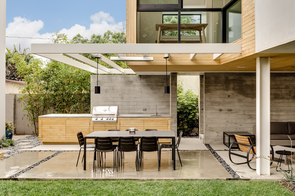 Foto di un patio o portico design con lastre di cemento e un tetto a sbalzo