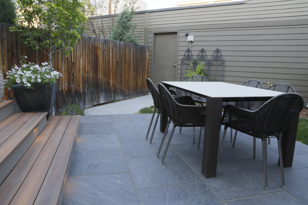 Foto de patio actual de tamaño medio sin cubierta en patio trasero con jardín de macetas y adoquines de piedra natural