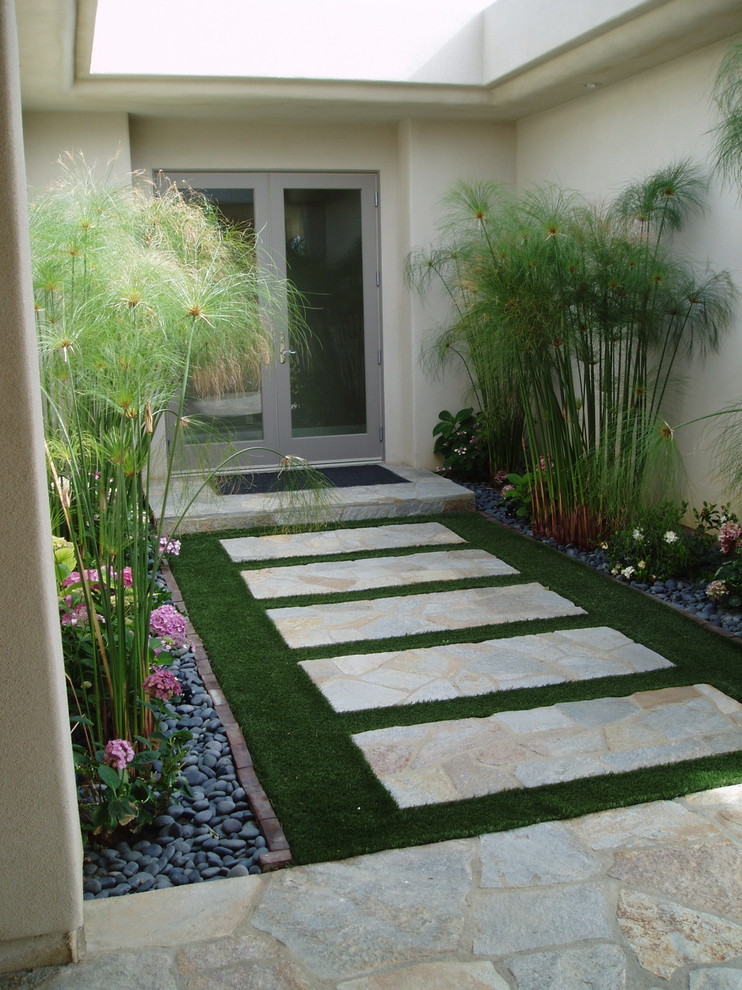 Design ideas for a medium sized contemporary back patio in San Diego with natural stone paving and a roof extension.