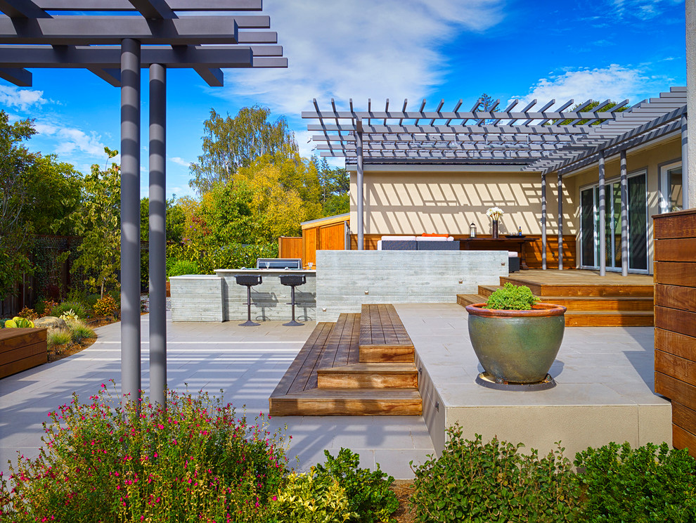 Immagine di un grande patio o portico minimal dietro casa con pedane e una pergola