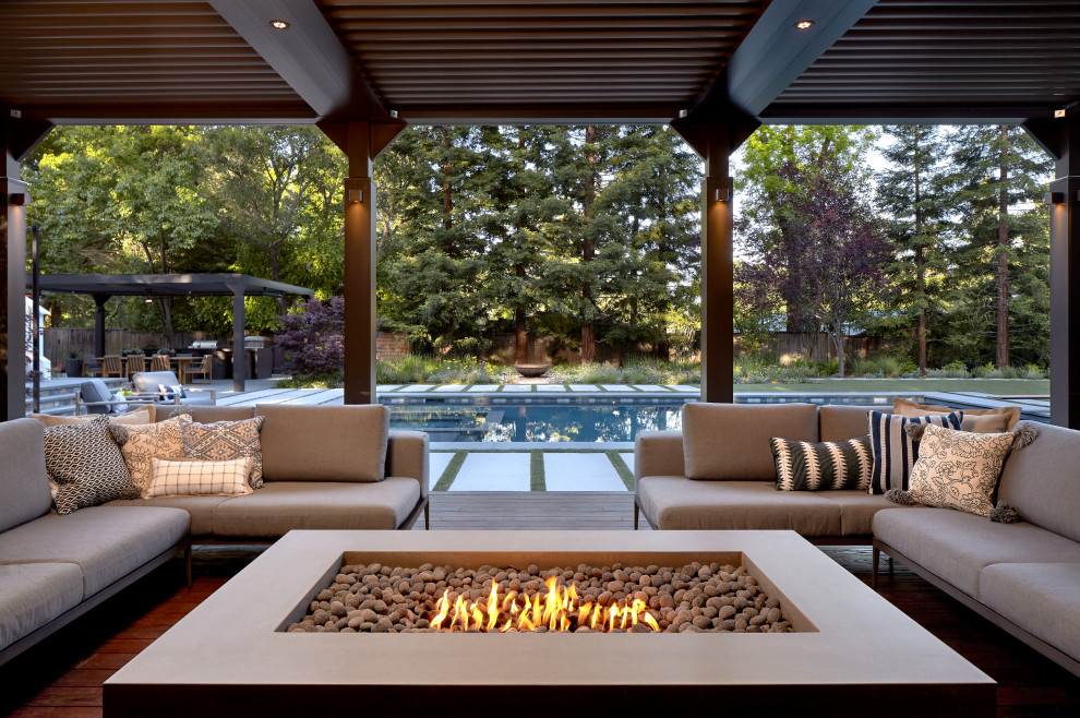 Huge trendy backyard stone patio photo in San Francisco with a fire pit and a pergola