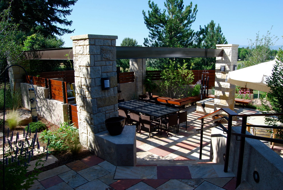 Immagine di un patio o portico minimal nel cortile laterale con pavimentazioni in pietra naturale e una pergola