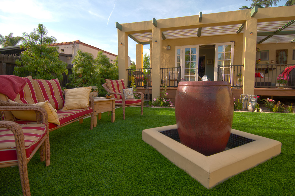 Medium sized mediterranean back patio in Los Angeles with a water feature, concrete paving and a pergola.