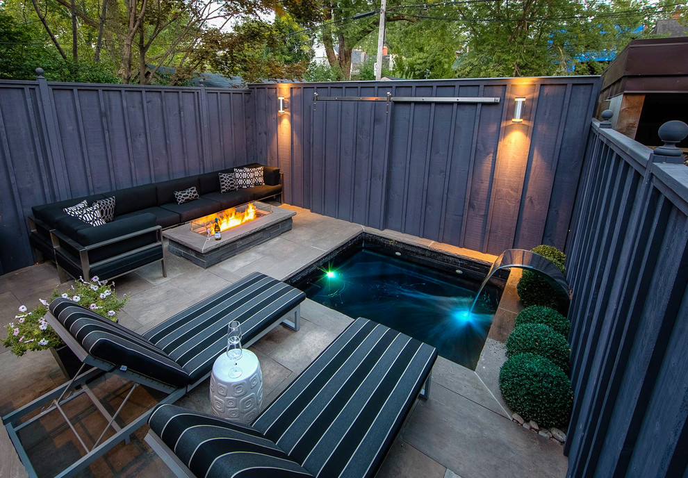 Patio - small contemporary backyard stone patio idea in Toronto with a fire pit