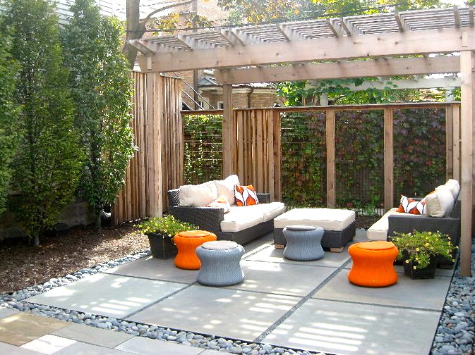 Modelo de patio clásico renovado de tamaño medio en patio trasero con losas de hormigón y pérgola