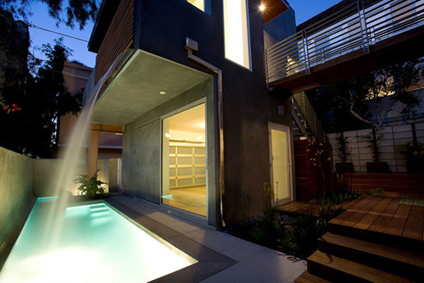 Mittelgroßer, Überdachter Moderner Patio hinter dem Haus mit Wasserspiel und Dielen in Los Angeles