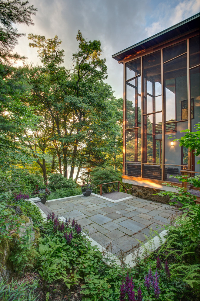 Пример оригинального дизайна: большой двор на заднем дворе в современном стиле с защитой от солнца