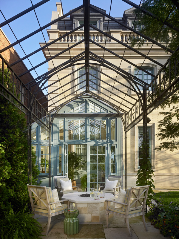 Réalisation d'un mur végétal de terrasse arrière méditerranéen avec des pavés en pierre naturelle et une pergola.