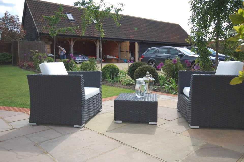 Rural back patio in London with natural stone paving.