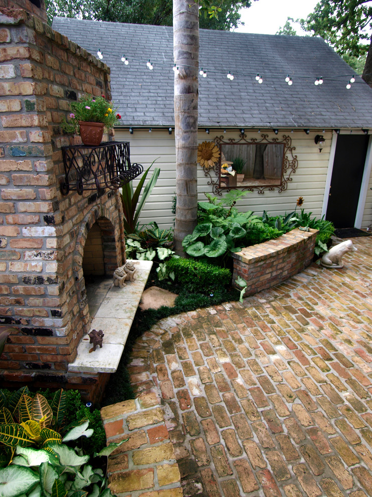 Patio - large traditional backyard brick patio idea in Houston with a fire pit and no cover