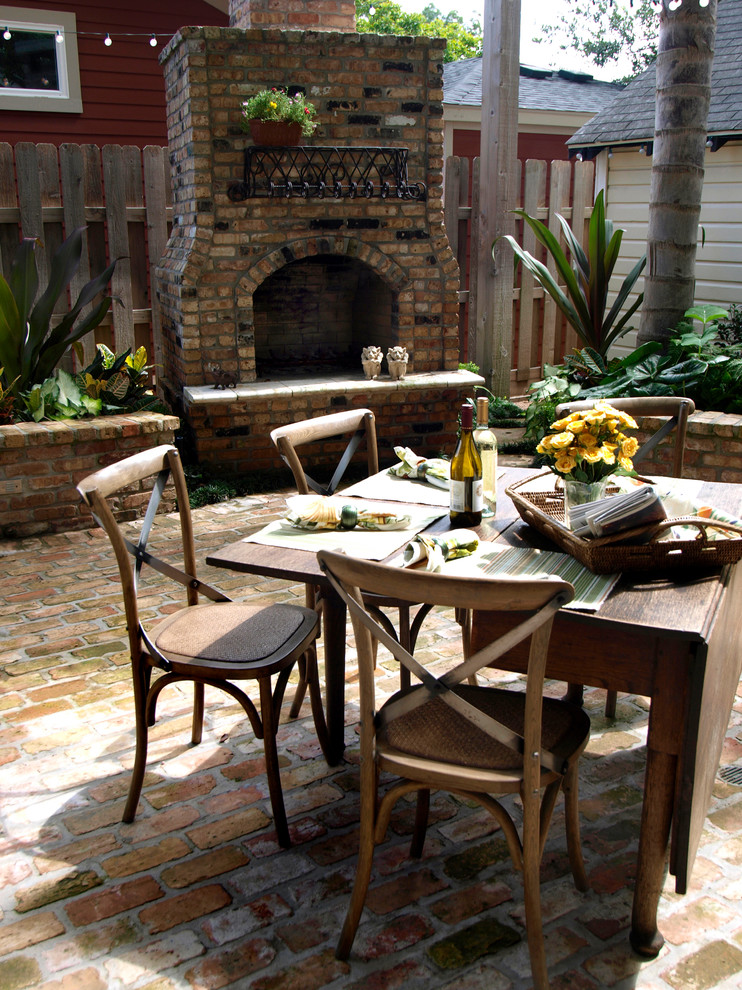Large elegant backyard brick patio photo in Houston with a fire pit and no cover
