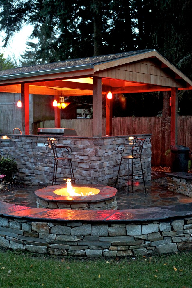 Large traditional back patio in Seattle with an outdoor kitchen, natural stone paving and a gazebo.